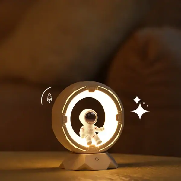 Lâmpada de plasma com figura de astronauta no centro, iluminação brilhante e detalhes de estrelas ao lado, sobre uma superfície de madeira.