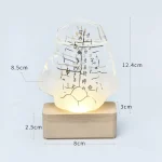 Lâmpada decorativa de vidro com escrita em caracteres japoneses, base de madeira, iluminação suave, dimensões indicadas: 12.4cm de altura, 8.5cm de largura, 3cm de profundidade.