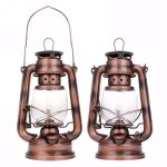 Duas lâmpadas de óleo antitempestade de estilo vintage com alça de metal e vidro transparente, colocadas lado a lado contra fundo branco.