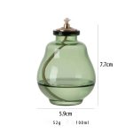 Frasco de vidro verde com tampa de metal e mecha de algodão, usado em experiências de ciência ou decoração temática.