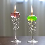Candeeiros a óleo com design de medusas, com lâmpadas acesas, base de vidro e detalhes em forma de tentáculos.
