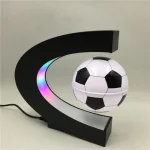 Luminária com design de bola de futebol e arco preto com luzes LED coloridas.
