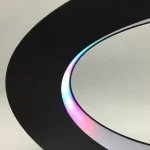 Lâmpada de plasma com luzes coloridas em tons de azul, roxo e rosa, com base preta e superfície de vidro transparente.