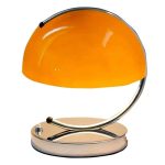 Candeeiro de mesa com base metálica e abajur amarelo brilhante, design retro, iluminação suave, ideal para decoração de espaço de estudo ou leitura.