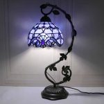 Candeeiro de mesa com abajur Tiffany azul e base decorativa em metal, iluminação suave, estilo vintage.