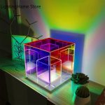 Luminária de mesa com cubos de acrílico iluminados em várias cores, criando um efeito de luzes vibrantes e ambiente moderno.