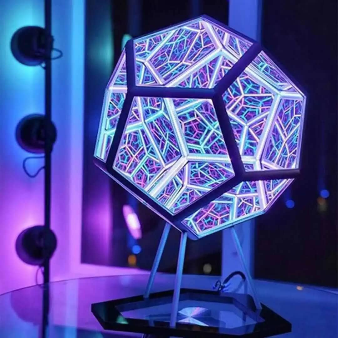 Luminária de design geométrico LED Luminária de mesa com estrutura geométrica iluminada por LEDs coloridos, com padrão de linhas e formas modernas, em ambiente escuro.