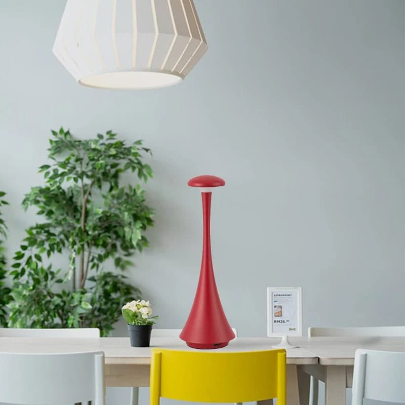 Luminária de mesa vermelha moderna Luminária de mesa vermelha com design elegante, colocada numa mesa de escritório com plantas e dispositivo digital ao fundo.