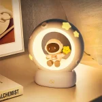 Lâmpada decorativa com um astronauta e estrelas amarelas, luz suave, ambiente acolhedor, decoração de quarto infantil ou espaço de estudo.