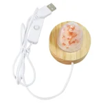 Lâmpada de sal rosa com base de madeira, ligada a um cabo USB, vista de cima.