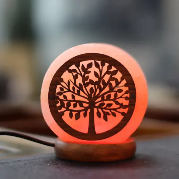 Lâmpada de mesa com design de árvore de corte a laser, iluminação suave em tom laranja, base de madeira, ambiente de interior acolhedor.
