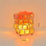 Luminária com estrutura de cubos de vidro translúcidos, iluminada por dentro, em tons quentes de laranja e amarelo, sobre fundo neutro.