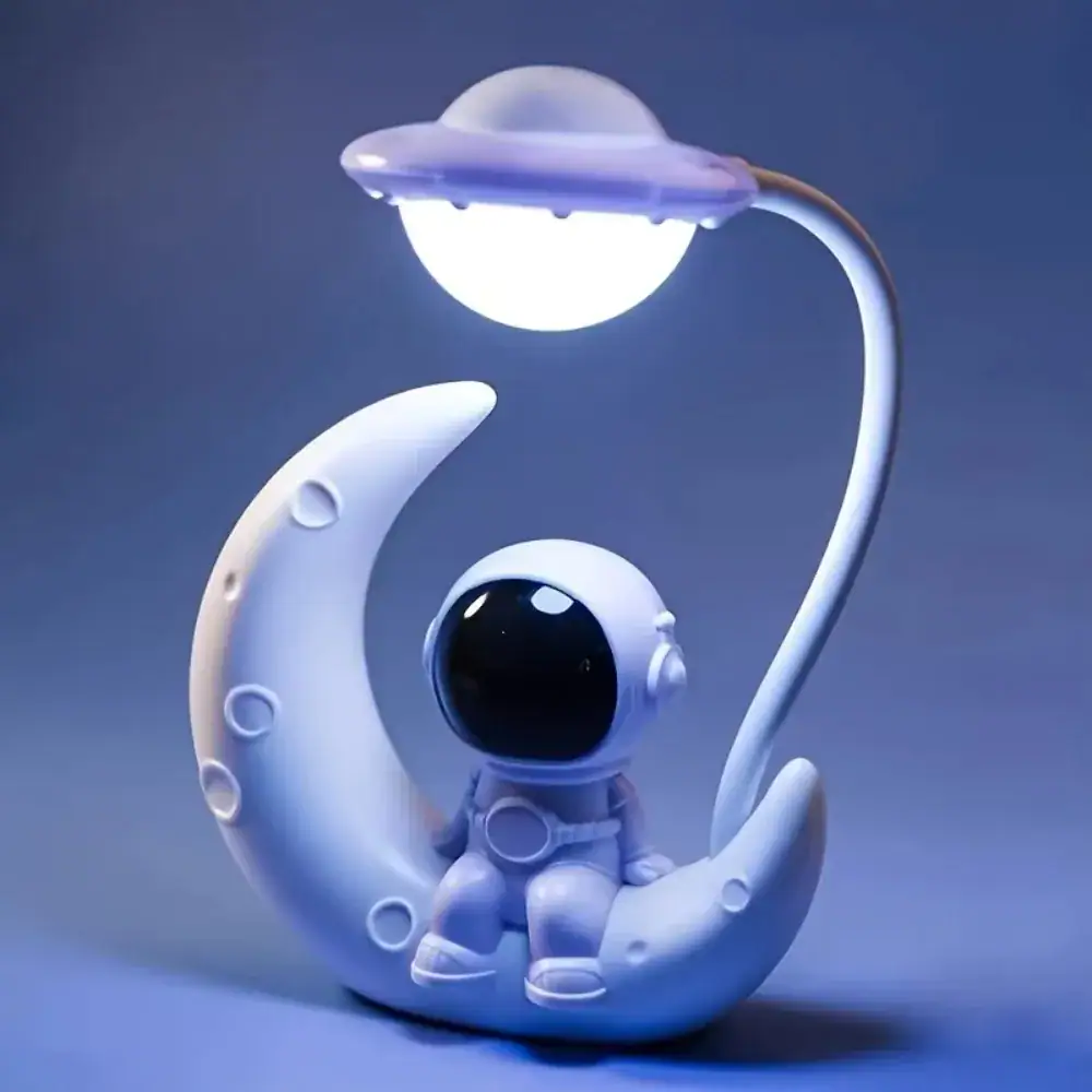 Luminária decorativa de astronauta sentado na lua com lâmpada em forma de estrela acima, iluminação suave e ambiente de espaço.