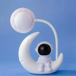 Luminária decorativa de astronauta sentado na lua com lâmpada de plasma em forma de estrela, ideal para decoração científica e educativa.
