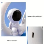 Robô astronauta branco com visor escuro, ajustável com luz de duas velocidades, conectado a uma base com entrada USB.