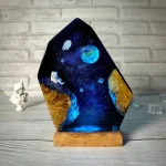 Lâmpada de plasma com ilustrações de espaço, planetas e estrelas, com base de madeira, vista frontal.