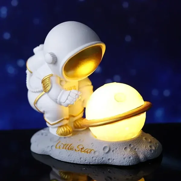 Miniatura de astronauta com capacete dourado a segurar um planeta LED brilhante, sobre base lunar com inscrição "Little Star".