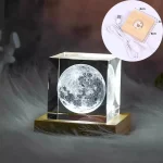 Lâmpada 3D da Lua com base de madeira, iluminação suave, detalhes da superfície lunar visíveis, em ambiente escuro, com cabo USB e interruptor.