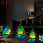 Três candeeiros pirâmide holográfica RGB com luzes coloridas em sala moderna, refletindo no tampo de mesa escuro, com iluminação suave e decoração contemporânea.