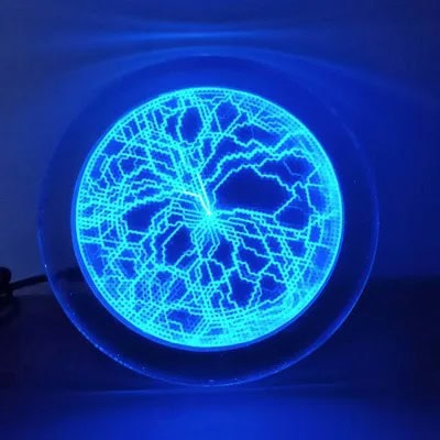 Disco de plasma azul com padrões de descargas elétricas visíveis, iluminado no escuro, mostrando as linhas de energia dentro do dispositivo.