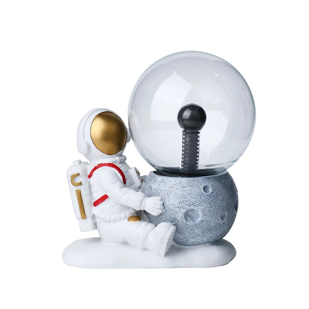 Estátua de astronauta com lâmpada de plasma Estátua de astronauta sentado ao lado de uma lâmpada de plasma em forma de planeta, com detalhes dourados no capacete e roupas brancas.