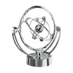 Modelo de átomo decorativo em metal com órbitas e partículas representando elétrons e núcleo, em acabamento prateado, sobre base circular.