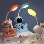 Três luminárias decorativas com personagens de ciência, cada uma com uma lâmpada de cor diferente, em diferentes posições e tamanhos, em fundo escuro.