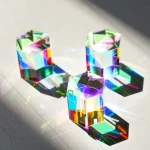 Três prismas de vidro coloridos com diferentes ângulos, refletindo luz e criando padrões de cores no chão.