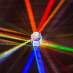 Prisma de cristal transparente refletindo luzes de cores diferentes, criando um efeito de dispersão de luz em várias direções.