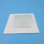 Quadro de vidro transparente com moldura branca, colocado sobre fundo azul, usado para demonstrações científicas ou atividades educativas.