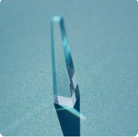 Cristal de vidro transparente com reflexão e sombra no fundo azul claro.