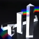 Prismas de vidro de diferentes tamanhos dispersando luz branca em cores do espectro.