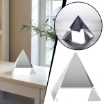 Piramide de cristal transparente com base sólida, vista de diferentes ângulos, refletindo luz natural.