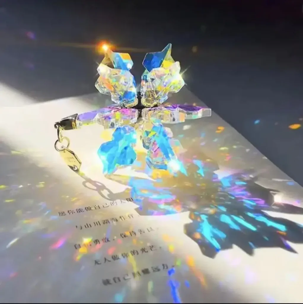Pequeno cristal de prisma com efeito de dispersão de luz, refletindo cores vibrantes e criando um arco-íris de luz na superfície.