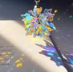 Cristal de prisma de luz com forma de floco de neve, refletindo cores do arco-íris, sobre uma página de livro com texto em chinês, criando efeitos de luz e sombra.