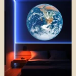 Globo terrestre luminoso em destaque na parede de um quarto escuro, com iluminação de LED azul e laranja, criando ambiente moderno e científico.