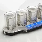Quatro tubos de ensaio transparentes com base de LED azul, usados para experiências científicas educativas.