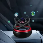 Esfera flutuante com elementos de plantas e água, rodeada por bolhas, sobre painel de carro, demonstração de física e magnetismo.