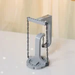 Pequena balança de precisão com base circular, braço vertical e correntes de plástico, usada para medições científicas em laboratório educativo.