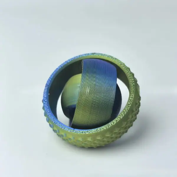 Bola de tênis com padrão de cores verdes, azuis e amarelas, vista de cima, com textura texturizada na superfície.