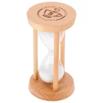 Relógio de areia com estrutura de madeira clara, vidro transparente e areia branca, usado para medir o tempo de 5 minutos.