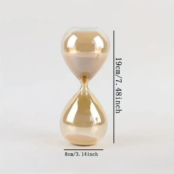 Ampulheta de vidro com areia dourada, altura de 19cm e diâmetro de 8cm, usada como decoração de ciência ou brinquedo educativo.