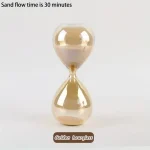 Ampulheta de vidro com areia dourada a fluir, indicando 30 minutos de tempo de fluxo de areia.