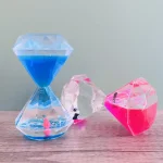 Relógio de areia de plástico com areia azul, rosa e transparente, decorativo para ciência ou brinquedos educativos.