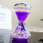 Relógio de areia de vidro com líquido roxo, mostrando a passagem do tempo com um design elegante e transparente.