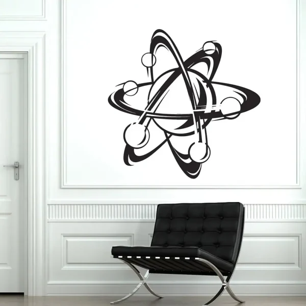 Símbolo atómico preto com órbitas e elétrons numa parede branca, decorando uma sala moderna com cadeira preta.