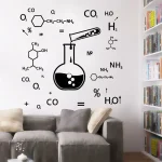 Parede decorada com símbolos de química, tubos de ensaio, moléculas e fórmulas químicas, em ambiente de sala de estar com sofá cinza e estantes de livros.