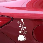 Adesivo branco com símbolos de átomos, moléculas e tubo de ensaio em fundo vermelho de carro.