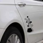 Adesivo de laboratório com tubos de ensaio, átomos e moléculas decorativos na porta de um carro branco.