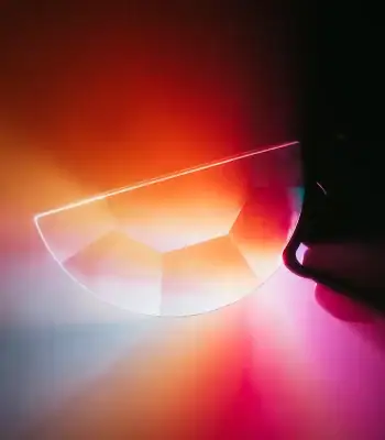 Lâmpada de plasma com efeito de luz colorida, mostrando uma linha de plasma brilhante e uma esfera parcialmente visível com cores vibrantes.